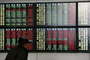 An investor looks at information displayed on an electronic screen at a brokerage house in Shanghai, December 8, 2014. REUTERS/Aly Song