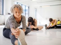 Females doing warm up exercise in fitness class. Women stretching in dance class.